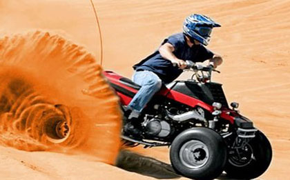 As the sun sets over the desert landscape, an evening desert safari with quad bikes kicks into high gear. The golden twilight bathes the sand dunes in warm hues as adventurous riders on quad bikes traverse the terrain, creating an exciting spectacle under the vibrant evening sky